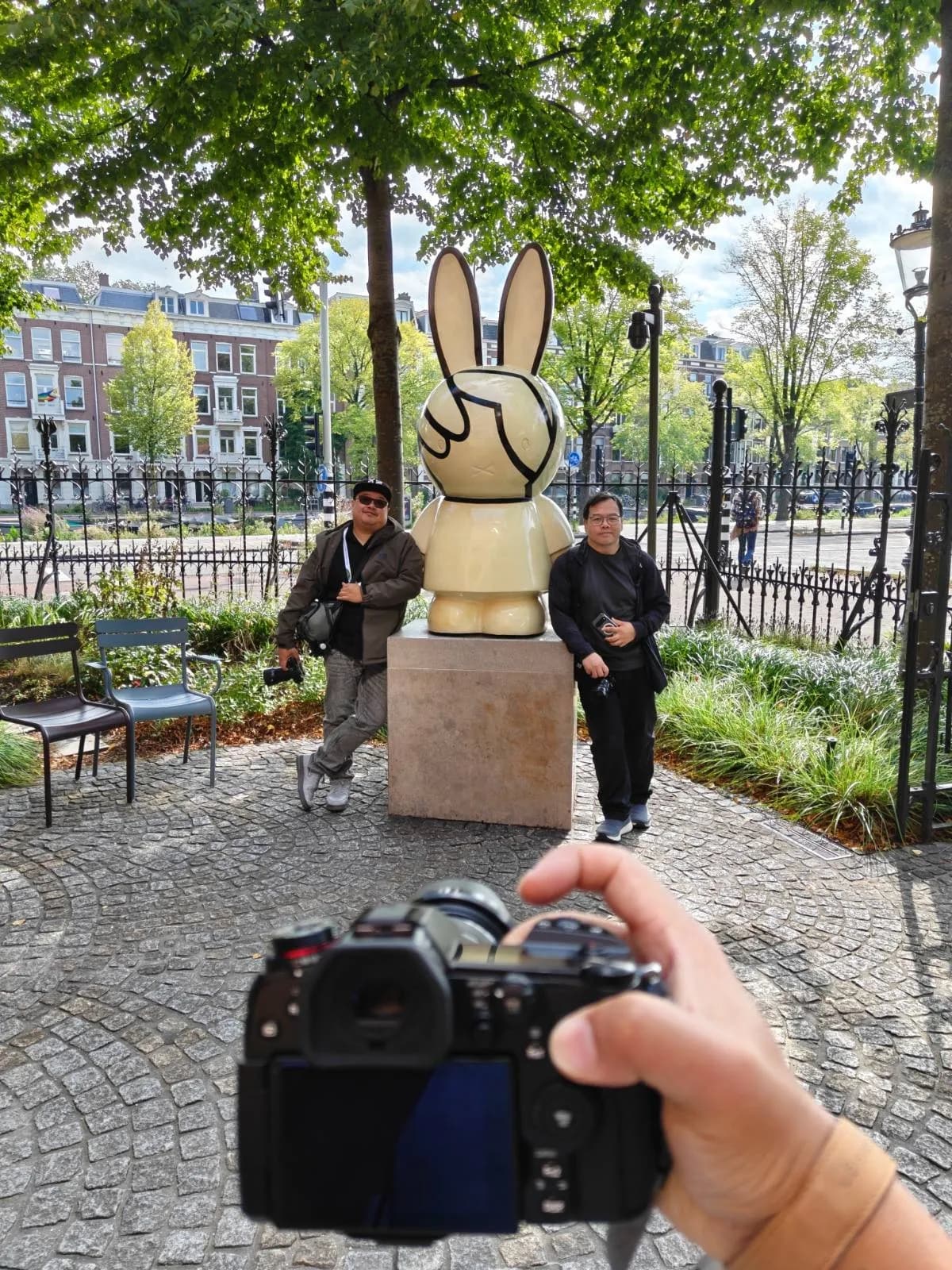 A racer framing a statue, camera held out in front