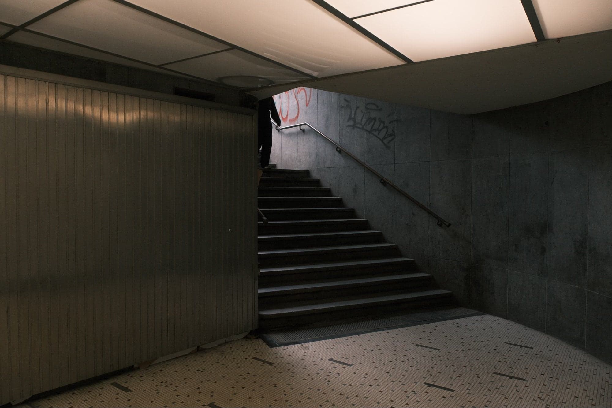 An empty underground stairway, lit from above · Anna Linmans